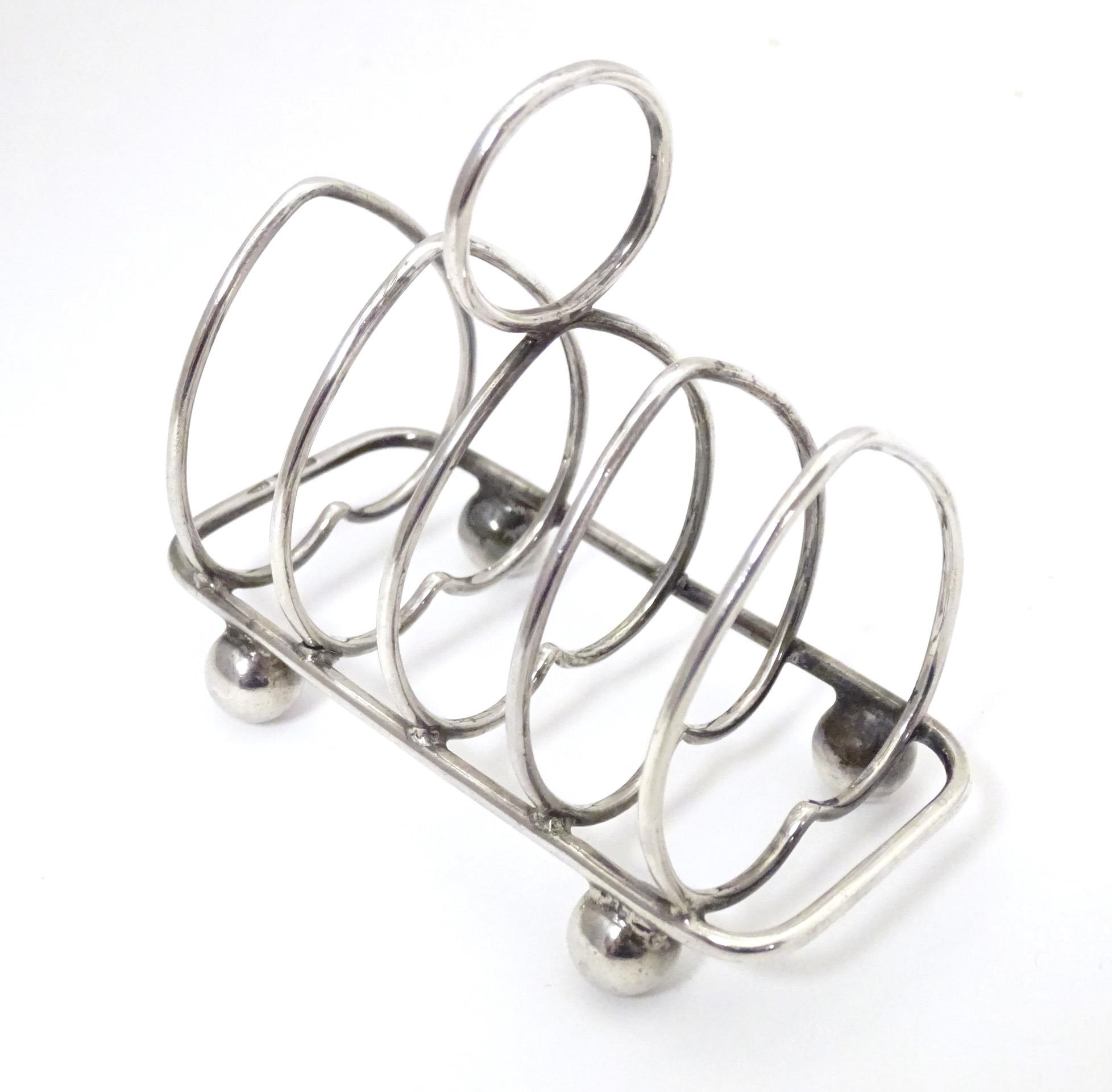 A silver five bar toast rack of heart form, hallmarked Sheffield 1911, maker Walker & Hall.