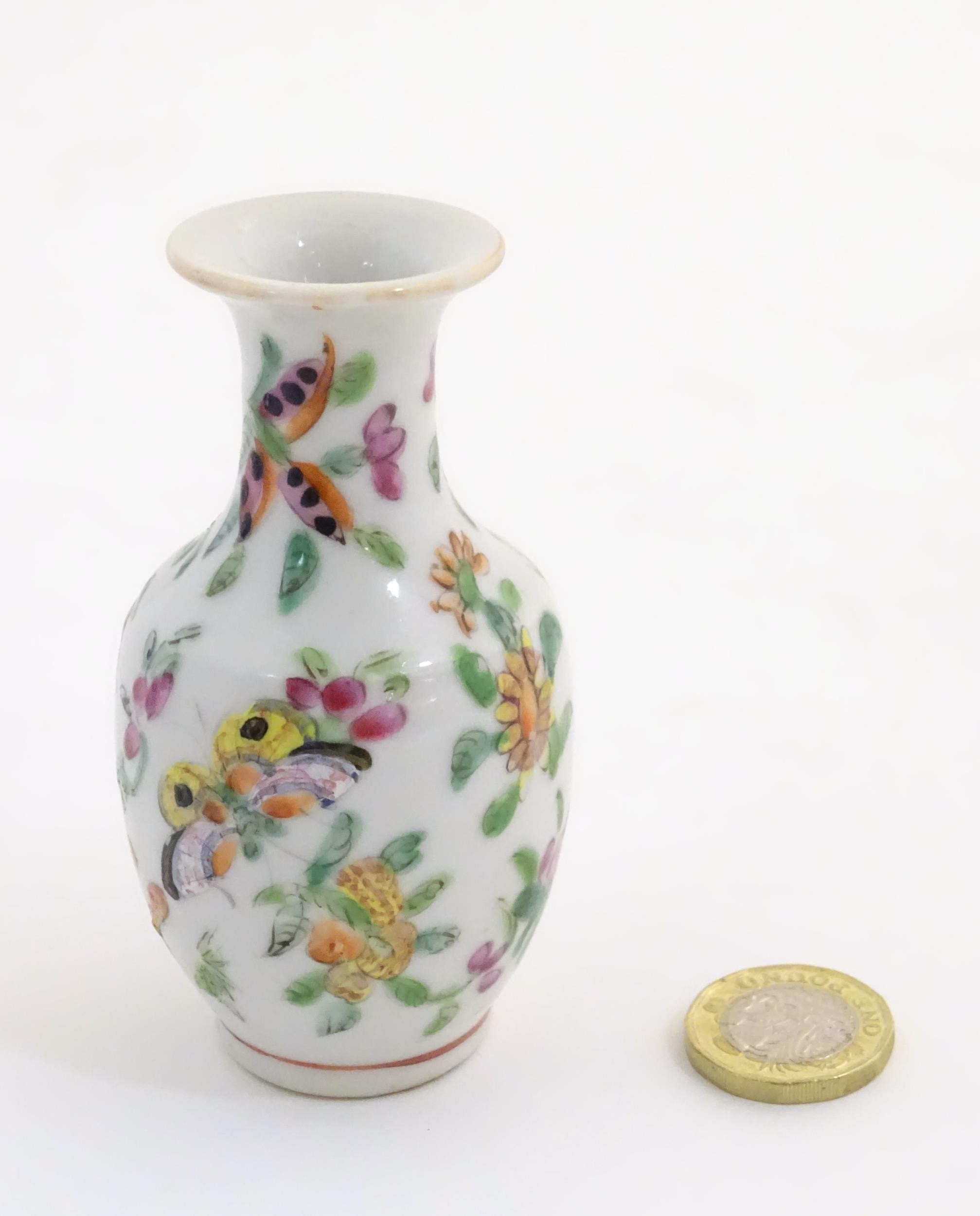 A small Chinese famille rose baluster vase decorated with butterflies amongst flowers and foliage. - Bild 2 aus 7