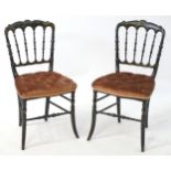 A pair of 19thC ebonised chairs with gilt painted decoration and having shaped top rails above