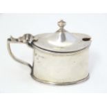 A silver mustard pot of neo classical design with blue glass liner. Hallmarked Chester 1902 maker