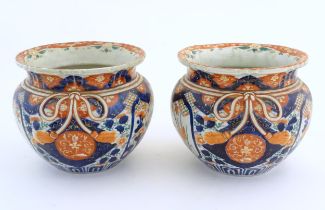 A pair of Oriental planters / jardinieres decorated in the Imari with flowers, foliage and tassel