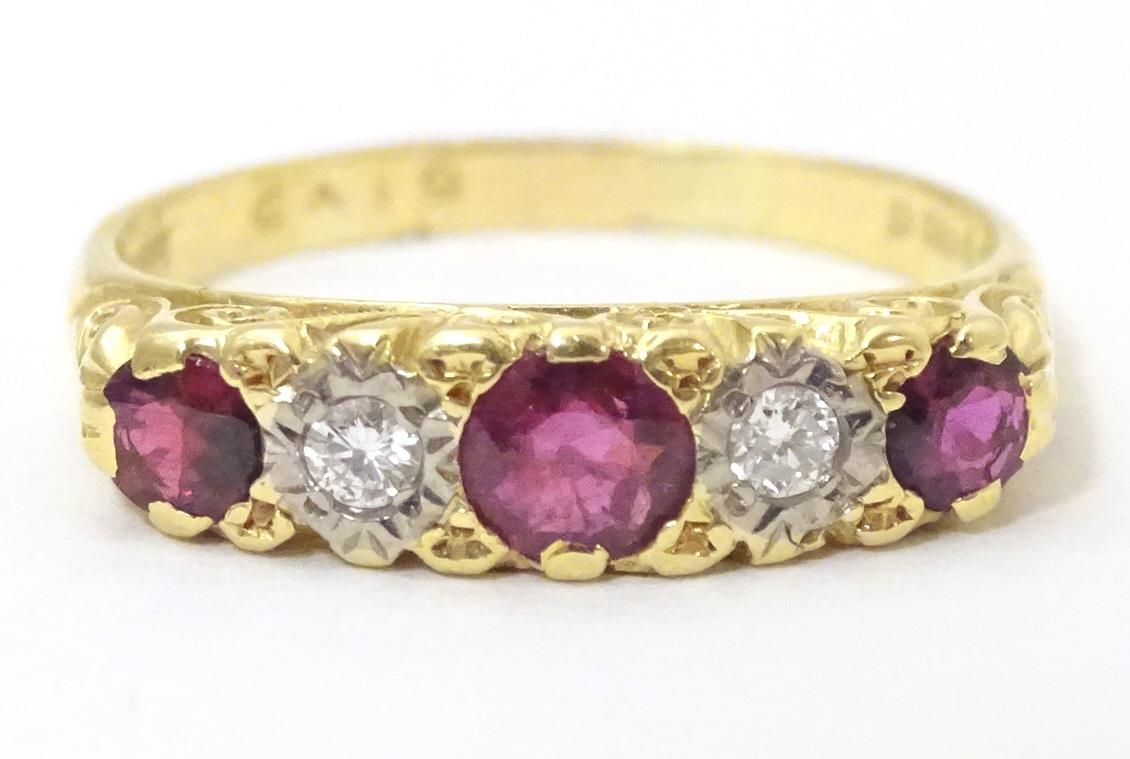 An 18ct gold ring set with diamonds and rubies in a linear setting. Ring size approx. U 1/2 Please