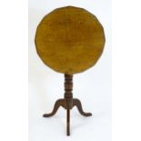 An early 19thC mahogany tripod table with a shaped reeded top above a turned pedestal base and three