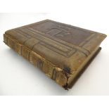 A 20thC photograph album with leather bound cover and musical mechanism. The mounts decorated with