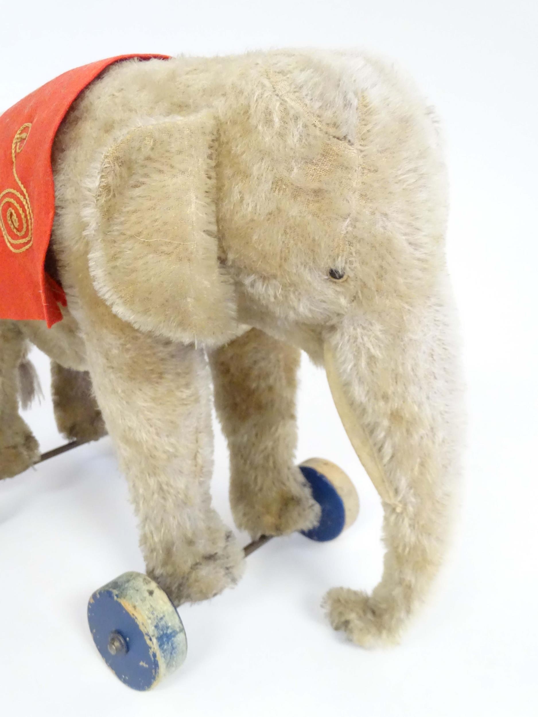 Toy: An early 20thC Steiff mohair pull along elephant toy with felt saddle, upon four wooden wheels, - Image 6 of 9