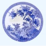 An Oriental blue and white charger with transfer decoration depicting a landscape scene with