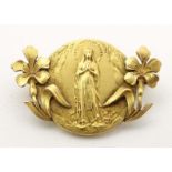 An early 20thC Continental gilt metal brooch depicting the Virgin Mary to centre flanked by floral
