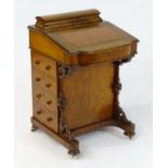 A mid / late 19thC walnut Davenport with a stationary compartment above an inset leather writing