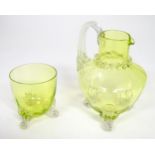 A yellow glass water jug with clear glass handle and feet, together with a matching glass. The jug 6