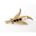 A 9ct gold brooch of foliate sprig form set with garnets and pearls. Aprox 1 3/4" long Please Note -