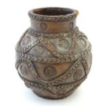 A studio pottery terracotta vase of bulbous form with impressed rosette detail and banded