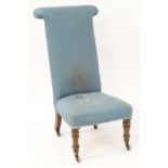 A mid 19thC prie dieu chair standing on turned tapering front legs terminating in brass castors. 20"