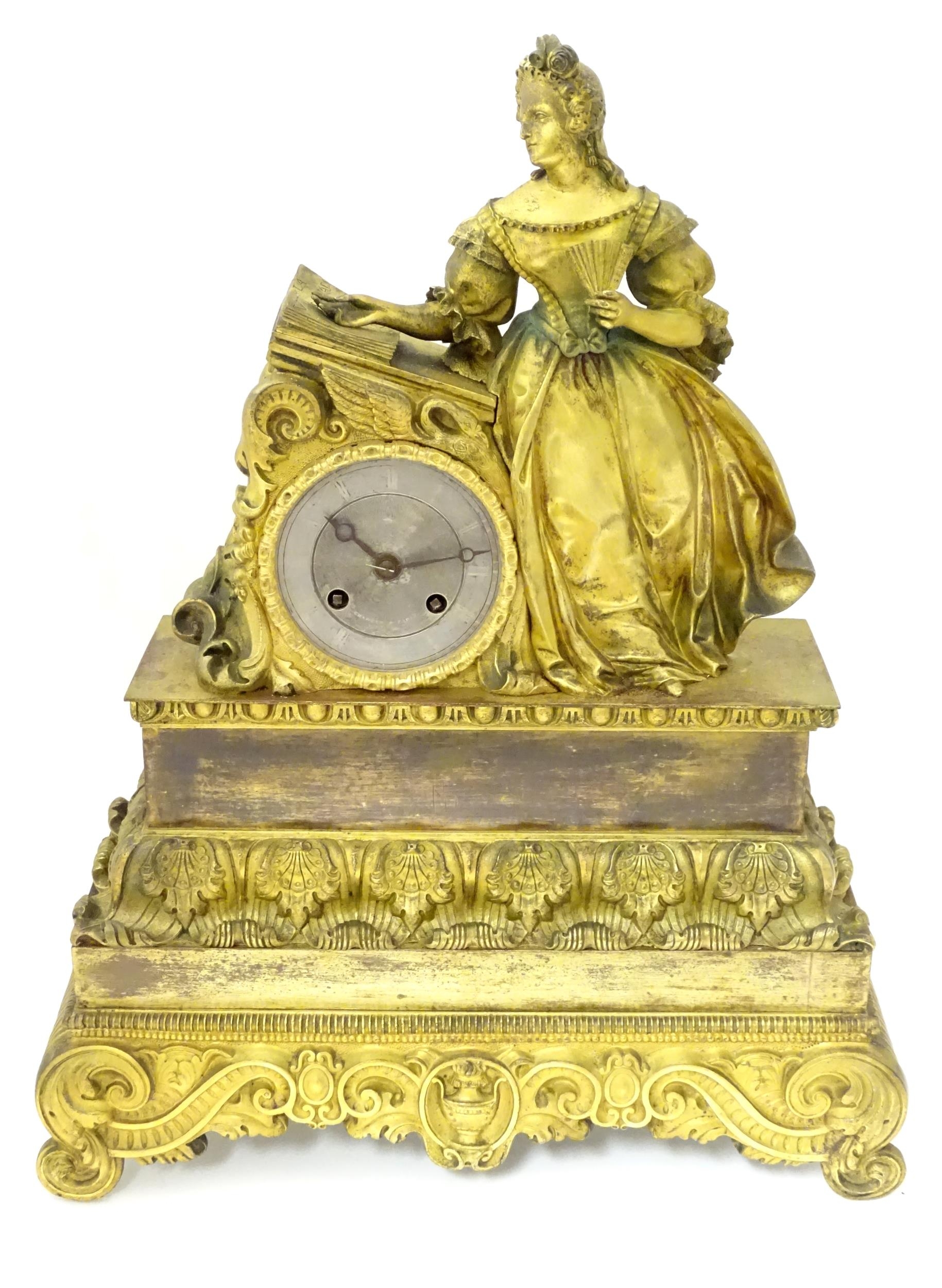 A 19thc French mantel clock with figural decoration. The silvered dial with moon hands, the 8 day