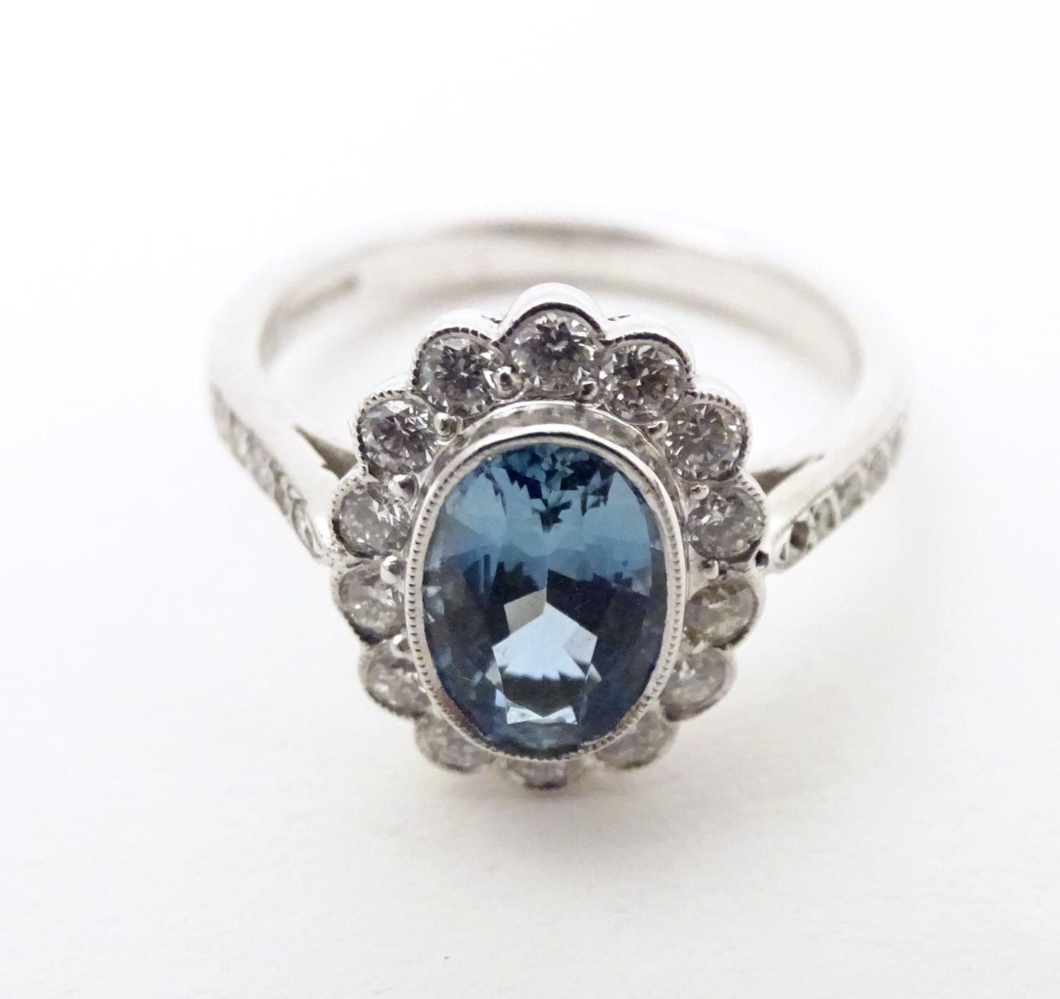 A 9ct white gold ring set with aquamarine coloured oval stone to centre bordered by diamonds with - Image 3 of 5