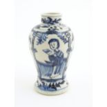 A small Chinese blue and white vase decorated with figures on a garden terrace with flowers and