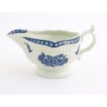 An 18thC blue and white Worcester sauce boat with double scroll handle and thumb rest, decorated