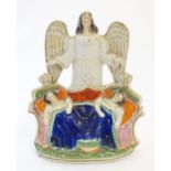 A Victorian Staffordshire pottery flat back figural group depicting an angel watching over two Royal