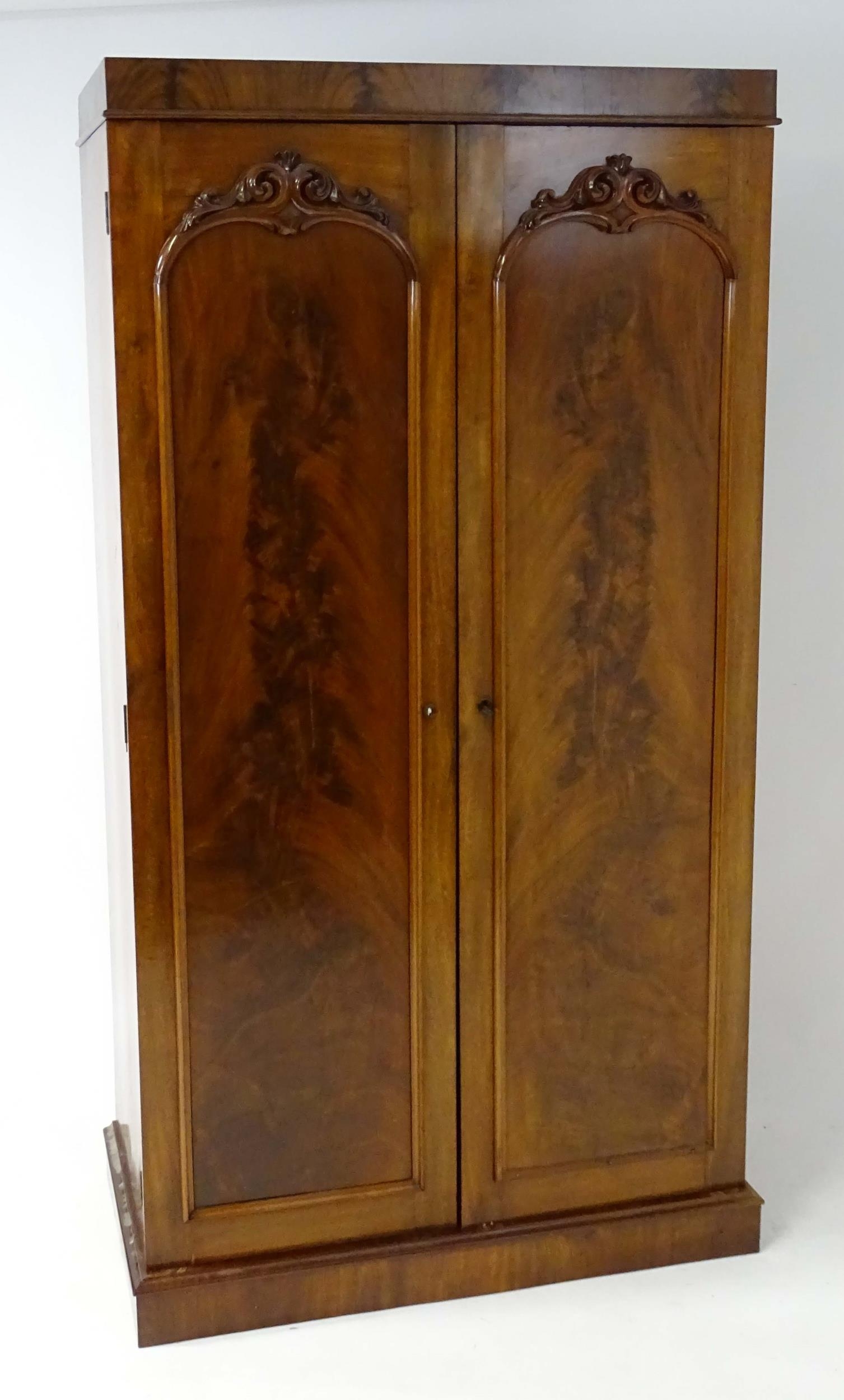 A mid 19thC mahogany double wardrobe with two panelled doors adorned with carved foliage and opening - Image 3 of 9