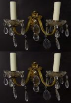 A pair of 20thC gilt twin branch wall lights, the gilt mounts supporting cut glass cups with