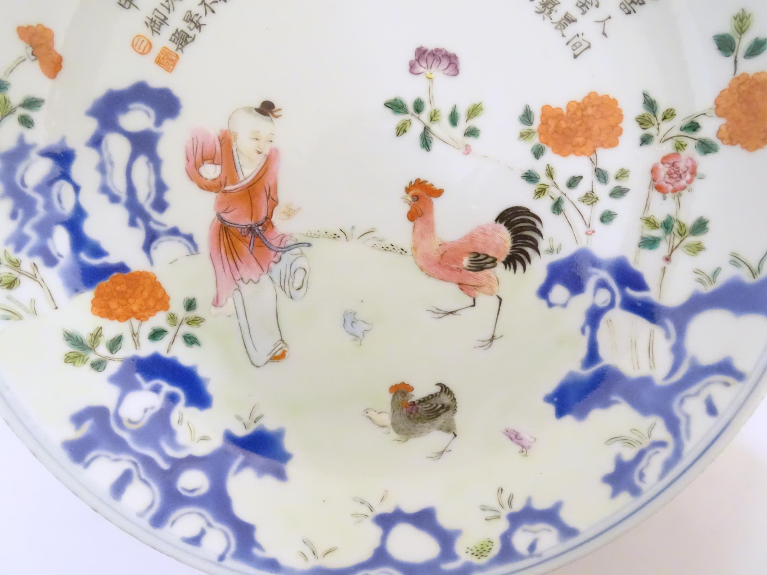 A Chinese famille rose plate decorated with a figure, a cockerel, hen and chicks in a garden with - Bild 3 aus 4