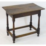 An 18thC oak table with a planked top above a peg jointed base with four turned legs and a box