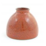 A Chinese water pot with a red glaze. Character marks under. Approx. 4" high Please Note - we do not