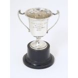 An Art Deco miniature silver twin handled trophy cup with socle base, hallmarked London 1937,