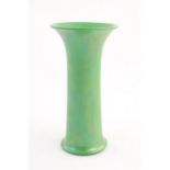A Ruskin pottery green lustre vase of cylindrical form with a flared rim. Impressed marks under