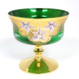 A Bohemian green glass pedestal bowl with gilt and enamel floral detail. Approx. 7" high x 7 1/2"