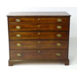 A late Georgian mahogany secretaire chest of drawers with a rectangular top above four graduated