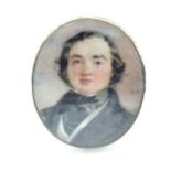 A 19thC watercolour portrait miniature depicting a gentleman in a black jacket and cravat, within an