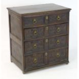 A 17thC and later oak chest of drawers with a carved top edge above panelled sides and two short