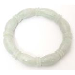 A green jade bracelet of bangle form with carved detail. Please Note - we do not make reference to