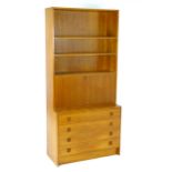 Vintage / Retro: A Teak bookcase with three shelves above a drop cupboard and four long drawers. 35"