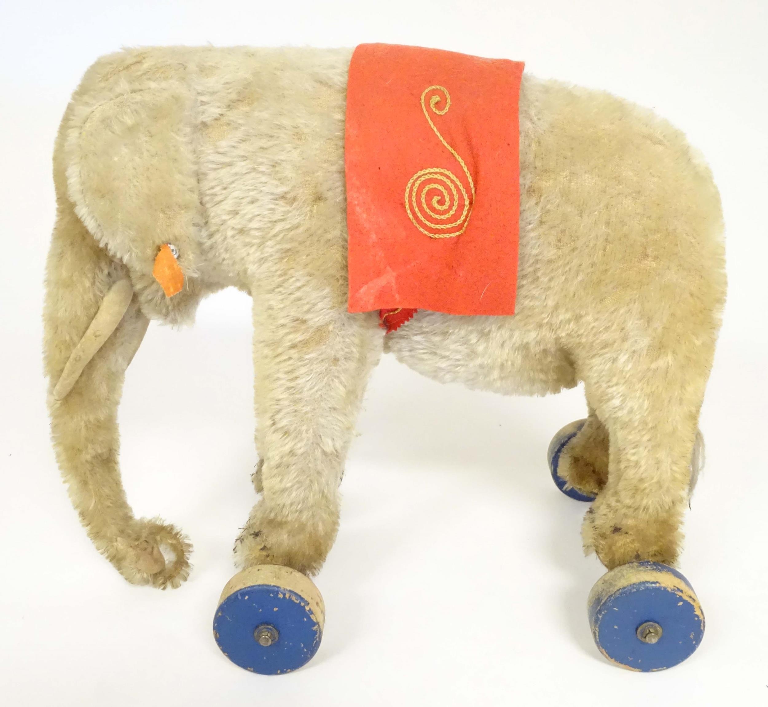 Toy: An early 20thC Steiff mohair pull along elephant toy with felt saddle, upon four wooden wheels, - Image 3 of 9