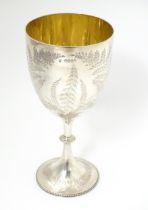 A Victorian silver trophy cup of goblet form with engraved fern detail and gilded interior,
