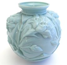 An Art Deco pale green glass vase with moulded floral decoration. 8'' high Please Note - we do not