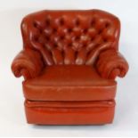 A mid century 'Wade' deep buttoned wingback Pegasus leather armchair raised on four castors. 38"