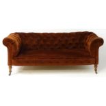 A late 19thC button back chesterfield sofa raised on turned tapering front legs. 81" wide x 37" deep