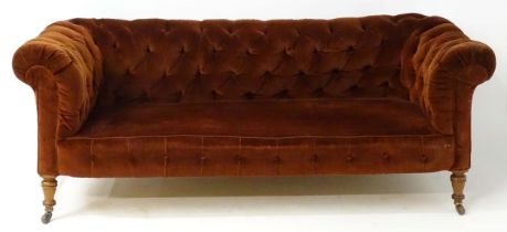 A late 19thC button back chesterfield sofa raised on turned tapering front legs. 81" wide x 37" deep