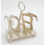 A late 20thC novelty 5-bar toast rack the divisions spelling 'TOAST' 4 1/4" x 5" high Please