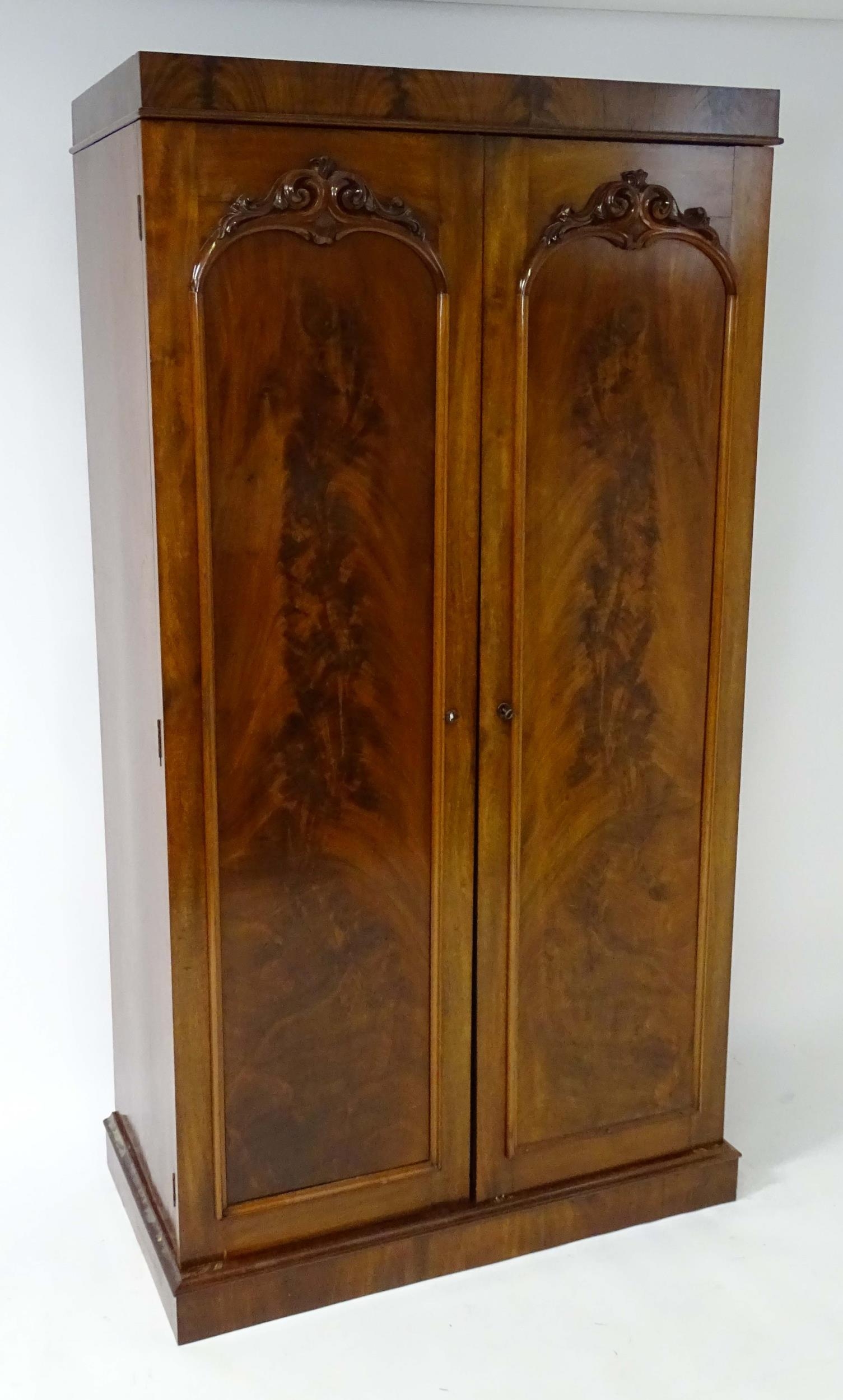 A mid 19thC mahogany double wardrobe with two panelled doors adorned with carved foliage and opening - Image 9 of 9