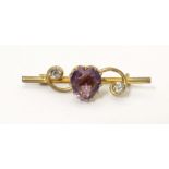 A gilt metal bar brooch set with central amethyst coloured heart shaped stone to centre flanked by