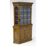 A late 19thC walnut cabinet with a moulded cornice above an astragal glazed door containing three
