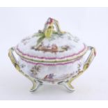 A French lidded tureen with foliate formed handles and standing on four out swept feet, the lid with