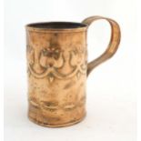 An Art Nouveau copper tankard with loop handle, decorated with embossed floral decoration and banded