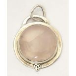 A white metal pendant set wit rose quartz cabochon. Approx 1 1/2" wide Please Note - we do not