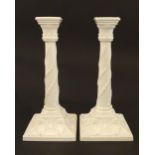 A pair of Royal Worcester candlesticks with relief twist decoration to columns and swag detail to