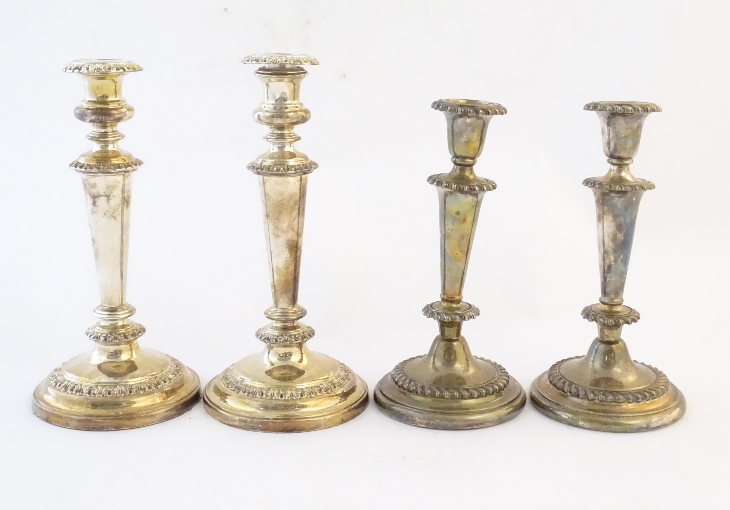 A pair of silver plate candlesticks. Together with another pair of silver plate candlesticks.