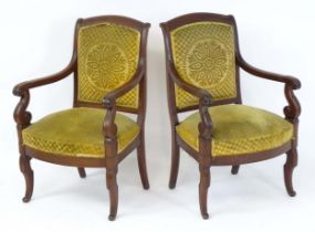 A pair of early / mid 19thC mahogany Empire armchairs, having shaped top rails above scrolled arms